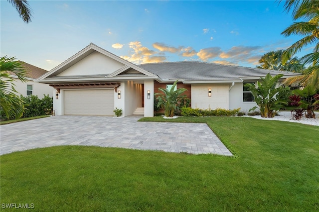 single story home featuring a yard and a garage