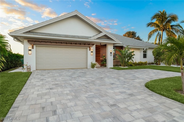 view of front of property with a garage and a yard