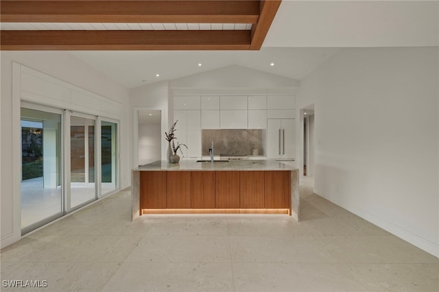 kitchen with white cabinetry, sink, tasteful backsplash, lofted ceiling with beams, and kitchen peninsula