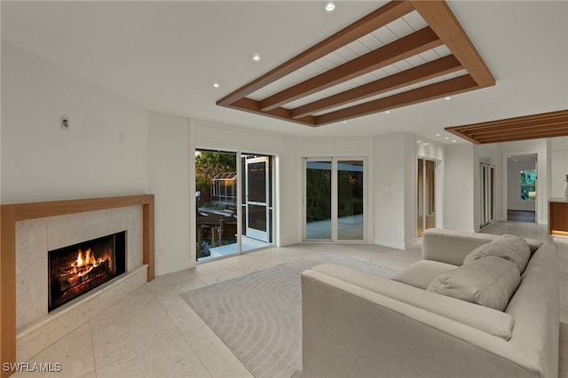 living room with a high end fireplace and beamed ceiling