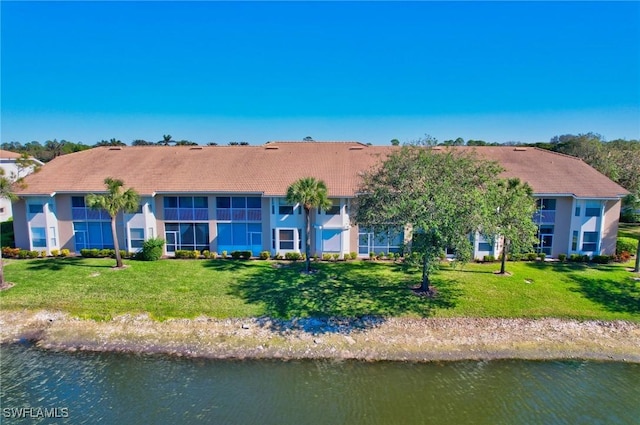 rear view of property with a yard and a water view