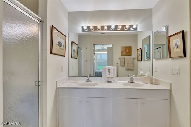 bathroom with vanity and a shower with door