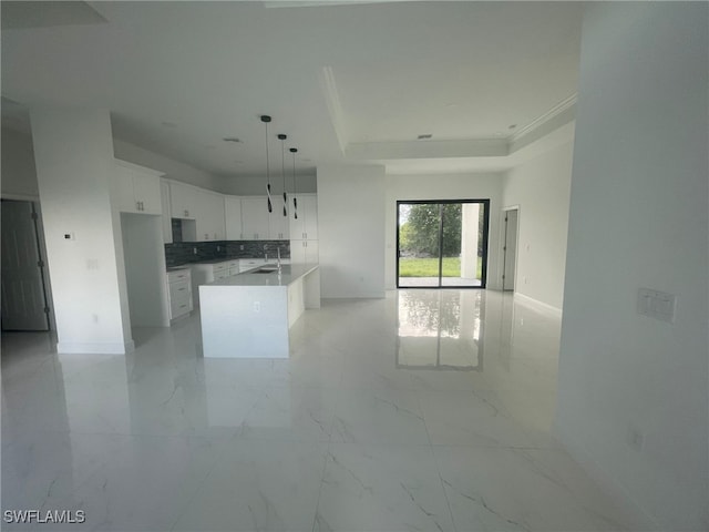 kitchen featuring white cabinetry, a center island, hanging light fixtures, and sink