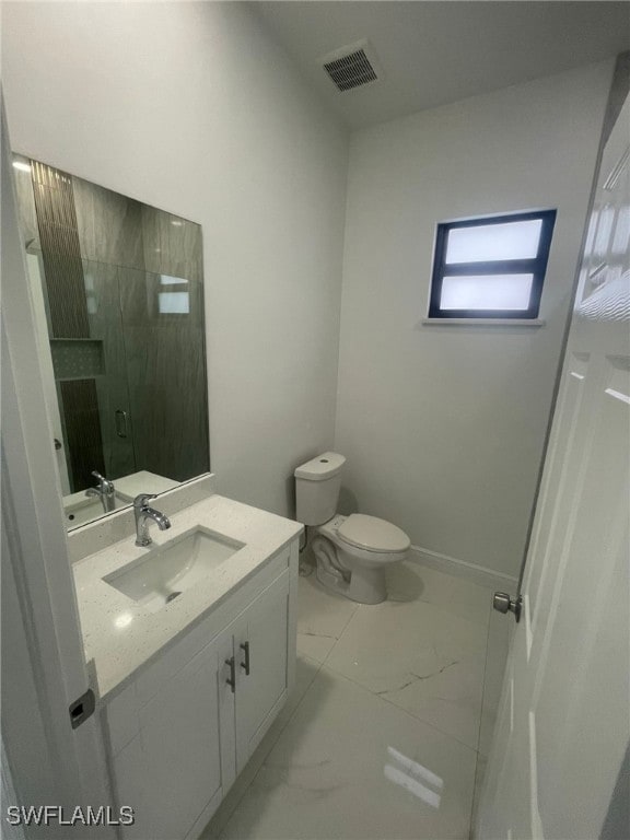 bathroom featuring vanity, toilet, and an enclosed shower