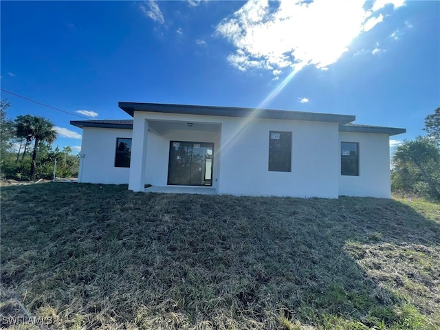 rear view of property featuring a lawn