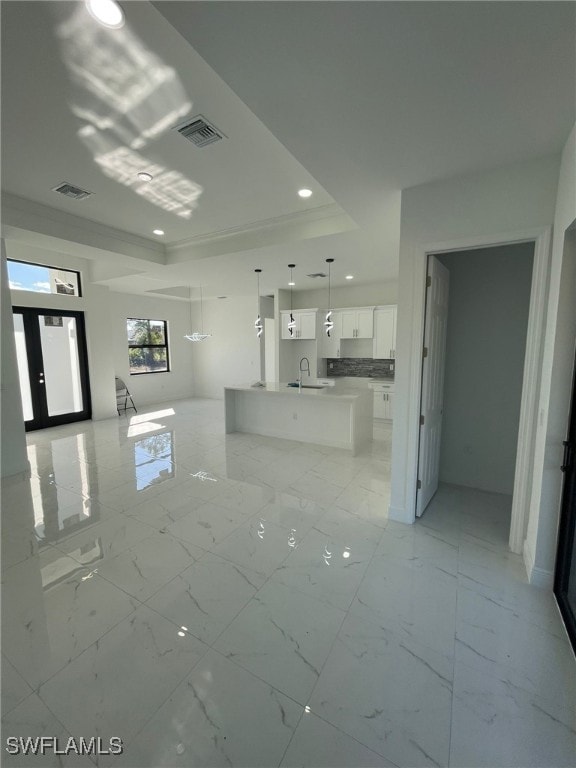 interior space with a raised ceiling and sink