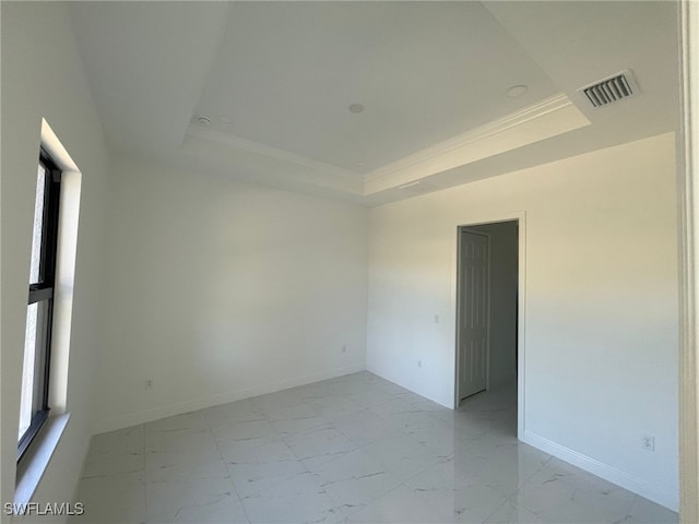 unfurnished room with a raised ceiling