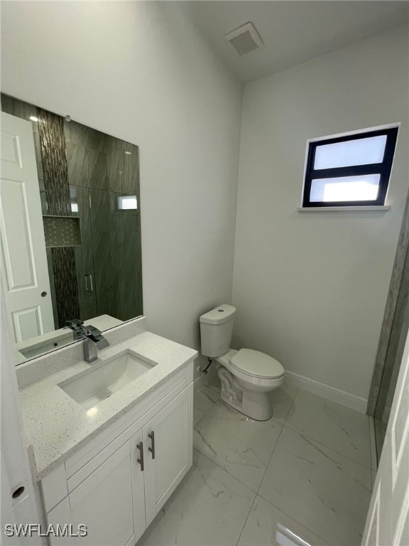 bathroom featuring vanity, an enclosed shower, and toilet