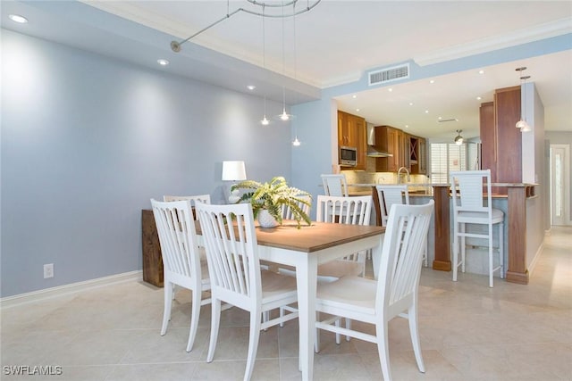 tiled dining area featuring crown molding