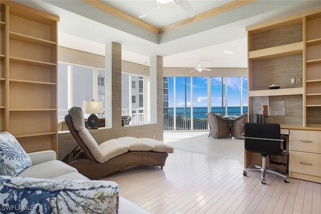 office area with a water view, crown molding, ceiling fan, and light hardwood / wood-style floors