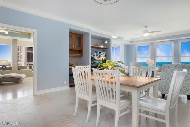 tiled dining space featuring ceiling fan and ornamental molding