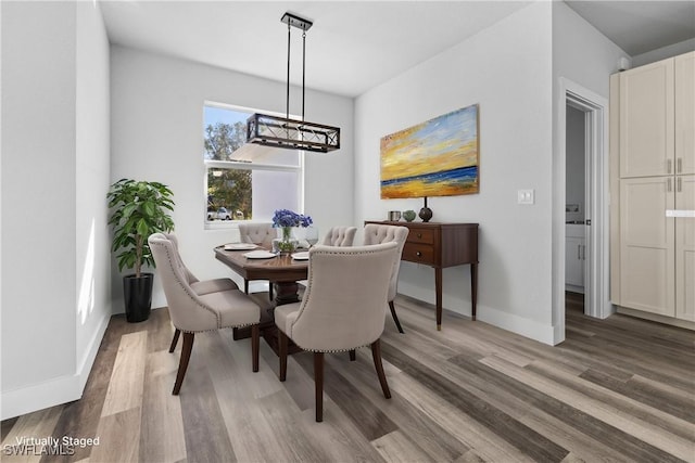 dining area featuring hardwood / wood-style floors and an inviting chandelier