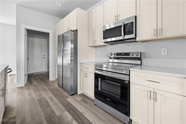 kitchen featuring light hardwood / wood-style floors, white cabinetry, and appliances with stainless steel finishes