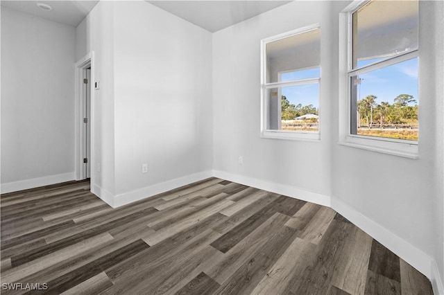 unfurnished room with dark hardwood / wood-style flooring