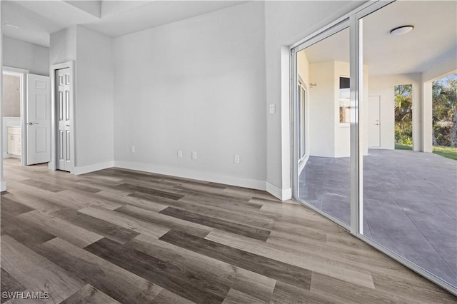 unfurnished bedroom featuring hardwood / wood-style flooring and connected bathroom