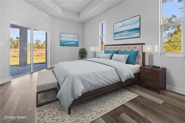 bedroom with access to outside and wood-type flooring