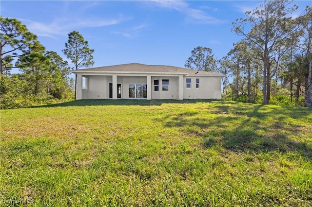 rear view of property featuring a yard