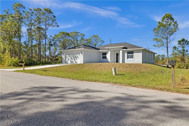 view of front of house with a garage and a front lawn