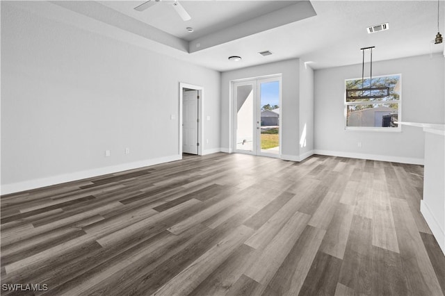 spare room with ceiling fan, dark hardwood / wood-style floors, and a tray ceiling