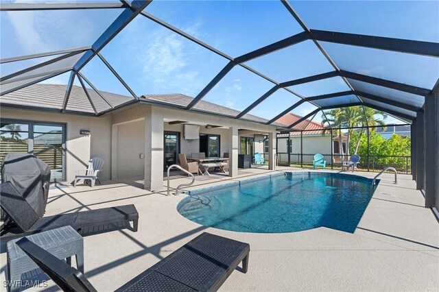 view of pool with a lanai, a grill, ceiling fan, and a patio