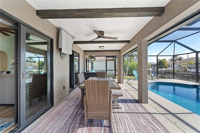 view of pool with ceiling fan, a water view, a patio, and glass enclosure