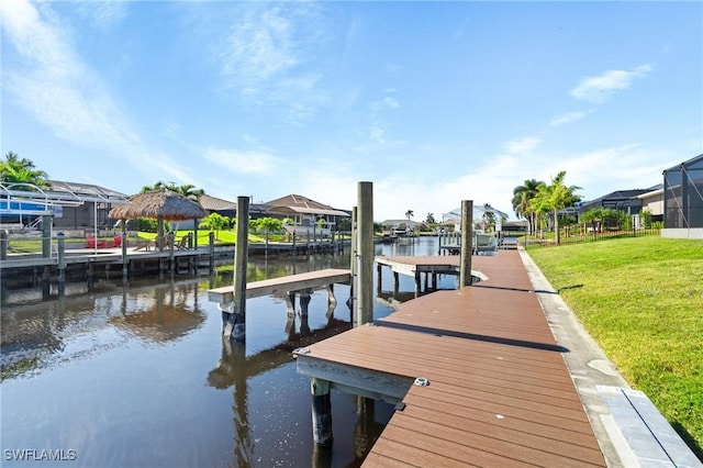 dock area with a lawn and a water view