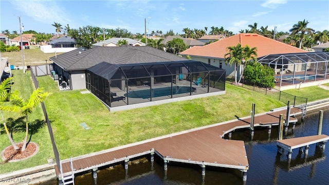 dock area with a patio, a yard, a water view, and glass enclosure