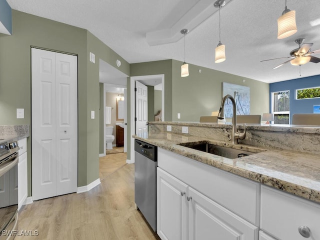 kitchen with pendant lighting, sink, appliances with stainless steel finishes, a textured ceiling, and white cabinets