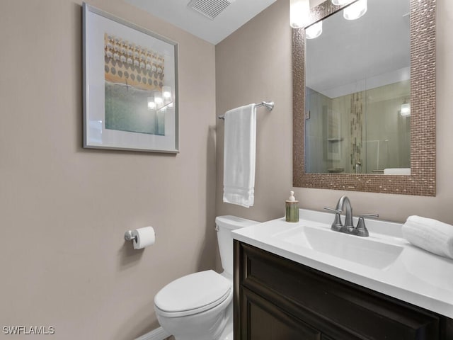 bathroom featuring vanity, a shower with door, and toilet