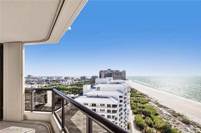 balcony with a water view and a view of the beach