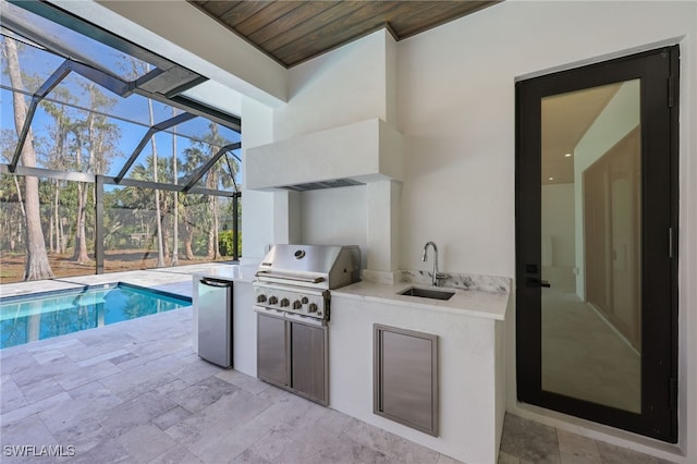 view of patio / terrace with a lanai, area for grilling, sink, and an outdoor kitchen