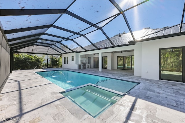 view of pool with an in ground hot tub, glass enclosure, ceiling fan, and a patio area