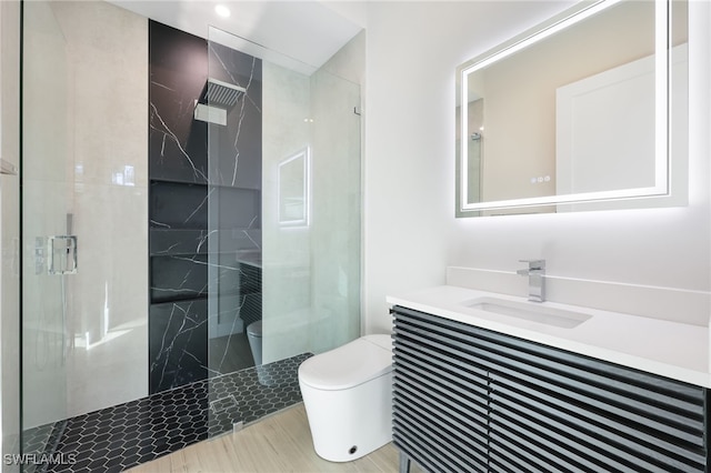 bathroom featuring vanity, toilet, and a shower with shower door