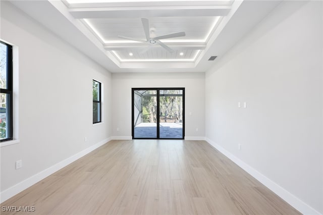 spare room featuring beamed ceiling, ceiling fan, and light wood-type flooring