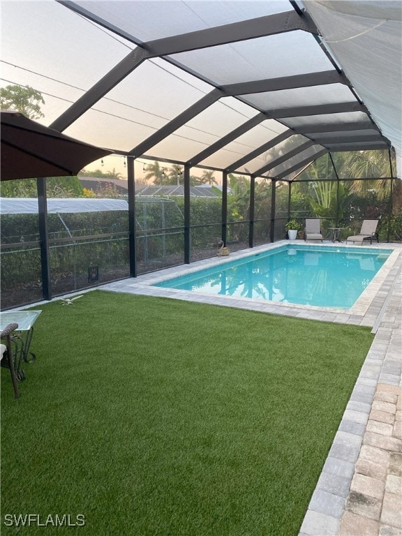 outdoor pool with a lanai, a lawn, and a patio