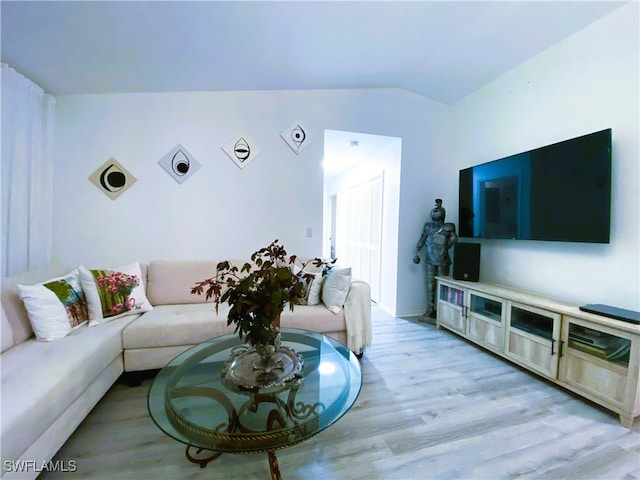 living area with lofted ceiling and light wood finished floors