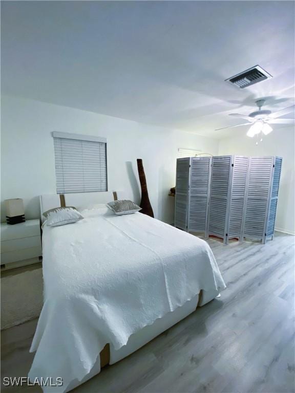 bedroom featuring visible vents, ceiling fan, and wood finished floors