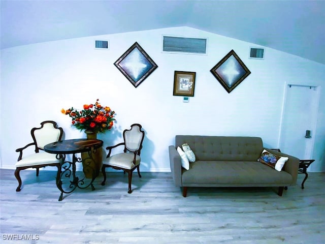 sitting room featuring vaulted ceiling, wood finished floors, and visible vents