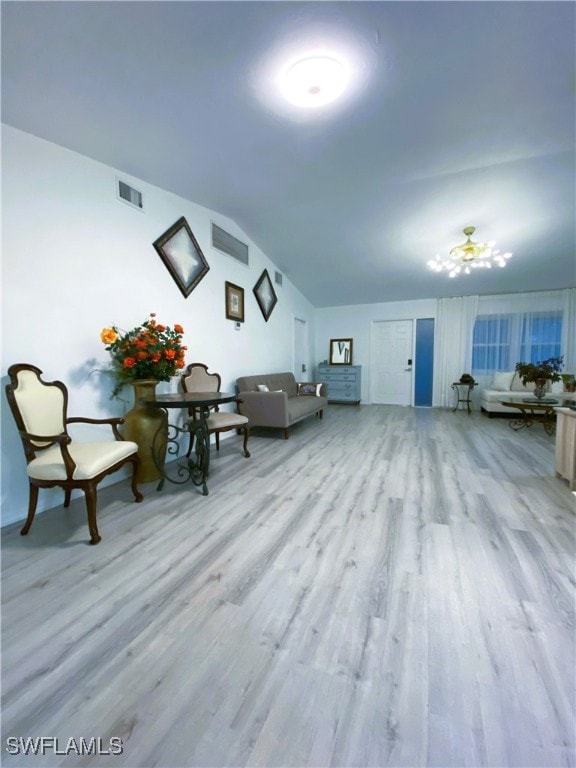 unfurnished living room with visible vents, wood finished floors, and vaulted ceiling