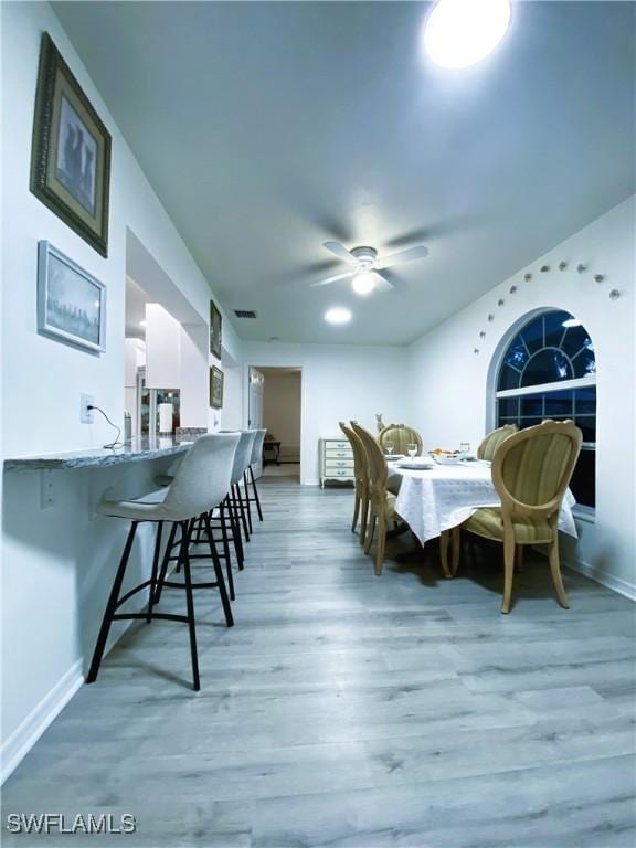 dining room with baseboards, light wood-style floors, and ceiling fan