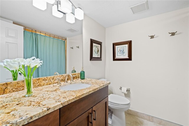 bathroom with vanity, tile patterned floors, and toilet