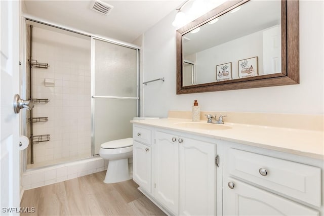 bathroom featuring hardwood / wood-style floors, vanity, toilet, and walk in shower