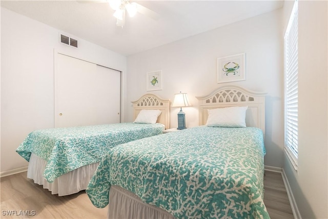 bedroom featuring hardwood / wood-style flooring, ceiling fan, and a closet