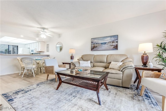 living room featuring ceiling fan and light hardwood / wood-style floors