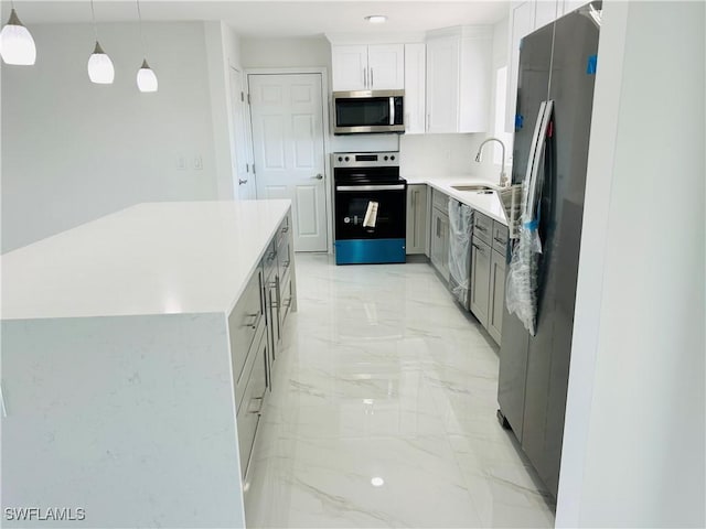 kitchen with sink, a center island, pendant lighting, white cabinets, and appliances with stainless steel finishes