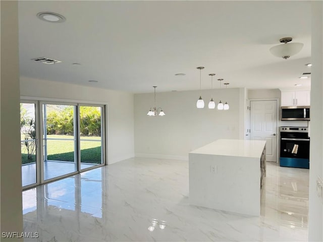 kitchen with a center island, white cabinets, hanging light fixtures, stainless steel appliances, and a chandelier