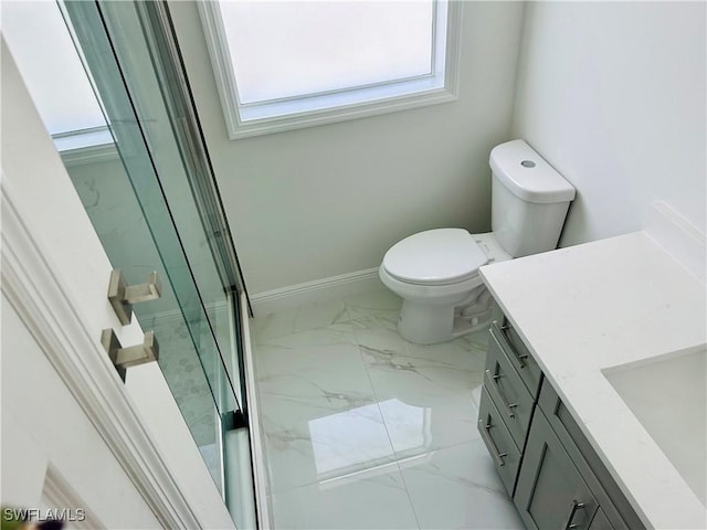 bathroom with a shower with door, vanity, and toilet