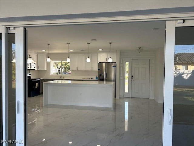 kitchen featuring sink, stainless steel fridge with ice dispenser, black / electric stove, pendant lighting, and white cabinets