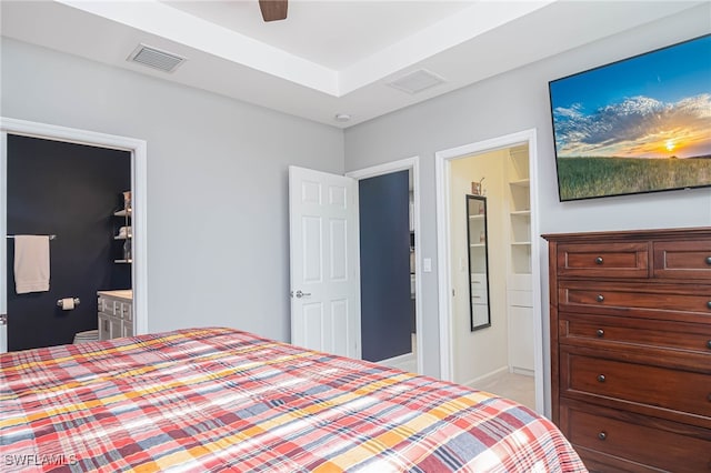 bedroom featuring a walk in closet, ensuite bathroom, and ceiling fan