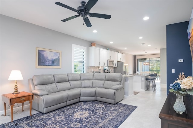 tiled living room featuring ceiling fan and a healthy amount of sunlight